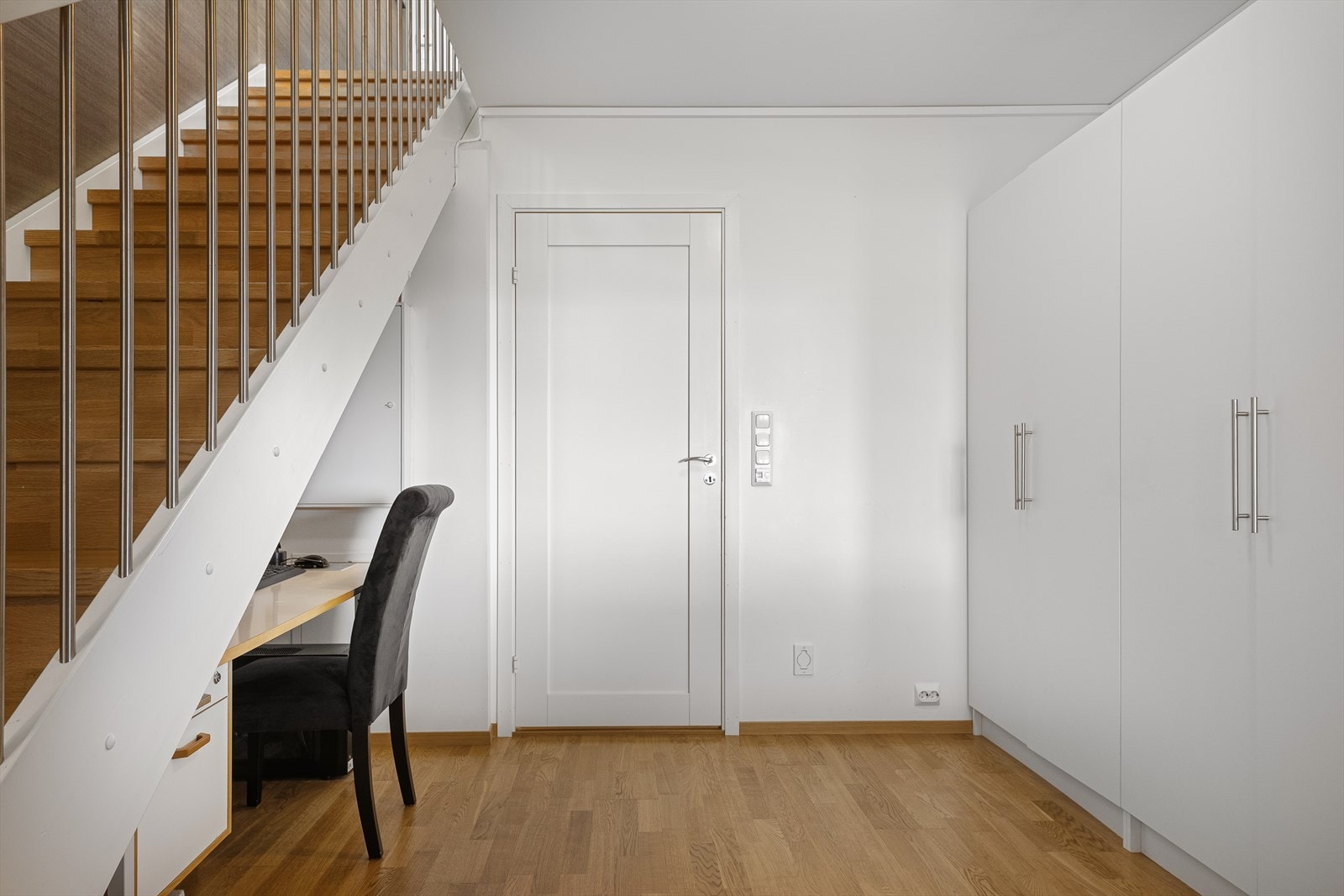 I gangen i underetasjen er plassen under trappen smart utnyttet til en liten arbeidsplass. Galleribilde