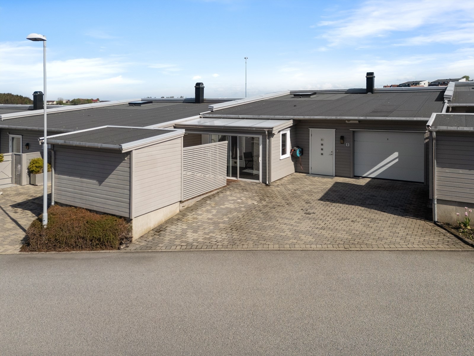 Eiendommen har en pent opparbeidet og steinbelagt gårdsplass med parkering. Galleribilde