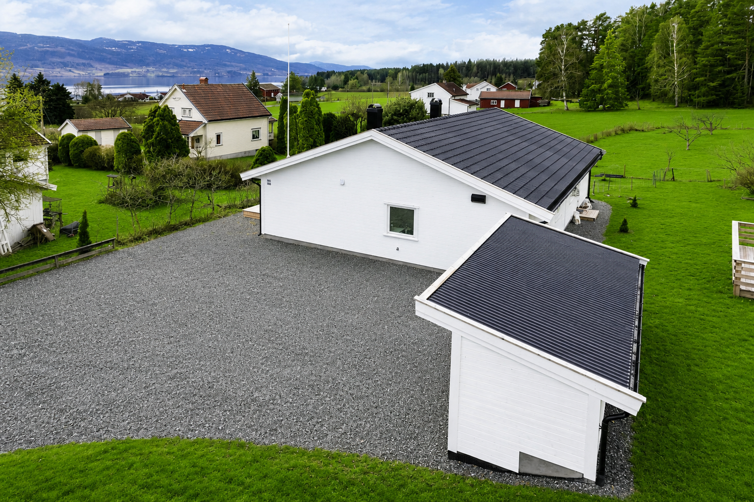 Boligen har et moderne uttrykk med pent opparbeidet uteområde og gode solforhold. (Gresset er gjort grønnere ved hjelp av ai) Galleribilde