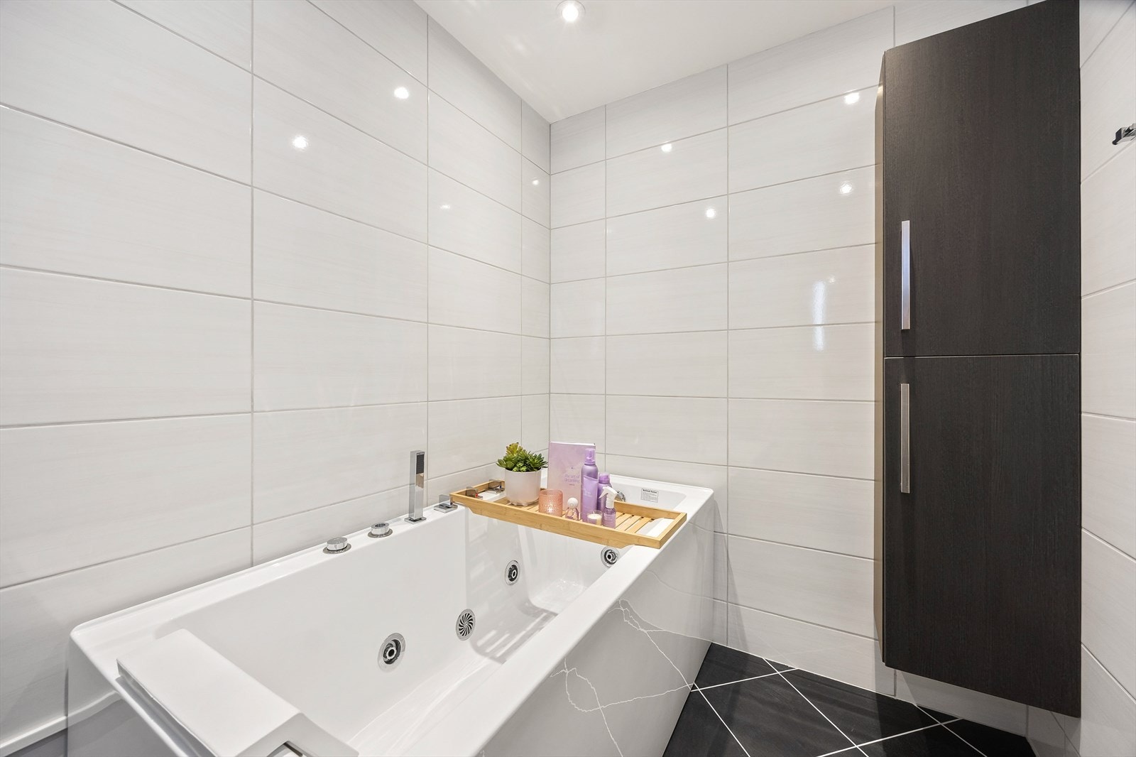 Badet er helfliset og har innredning med glatte fronter, gulvvarme og downlights. Galleribilde