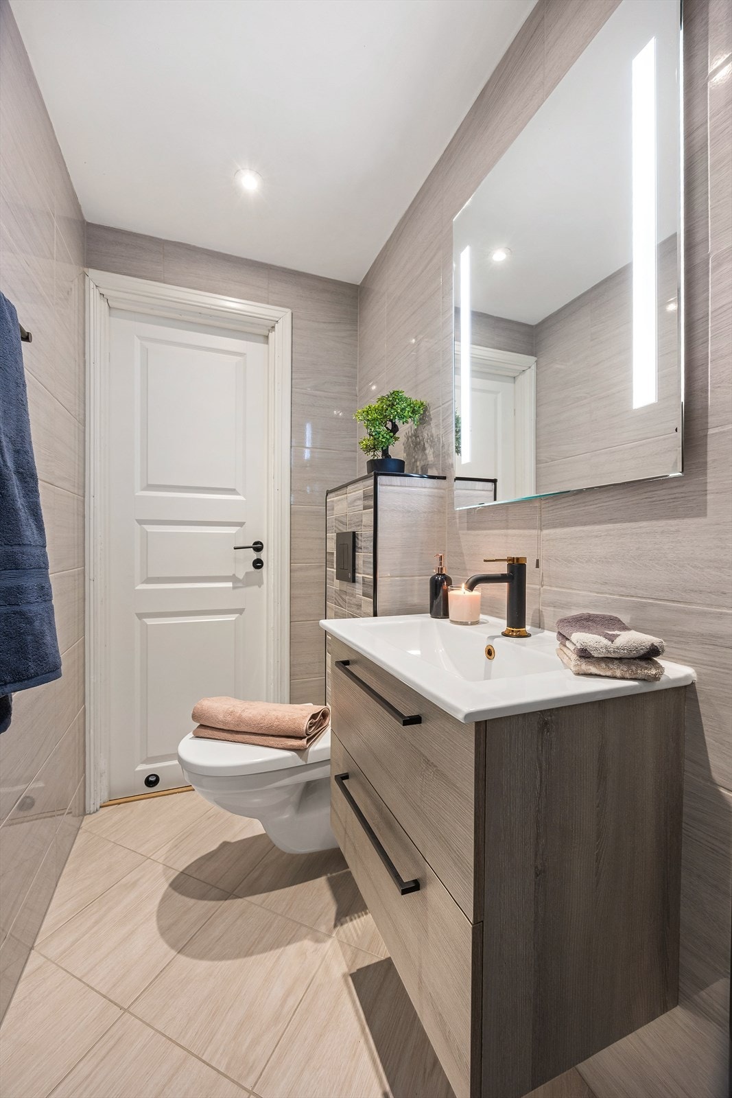 Badet er helfliset og har servantinnredning med glatte fronter. Galleribilde