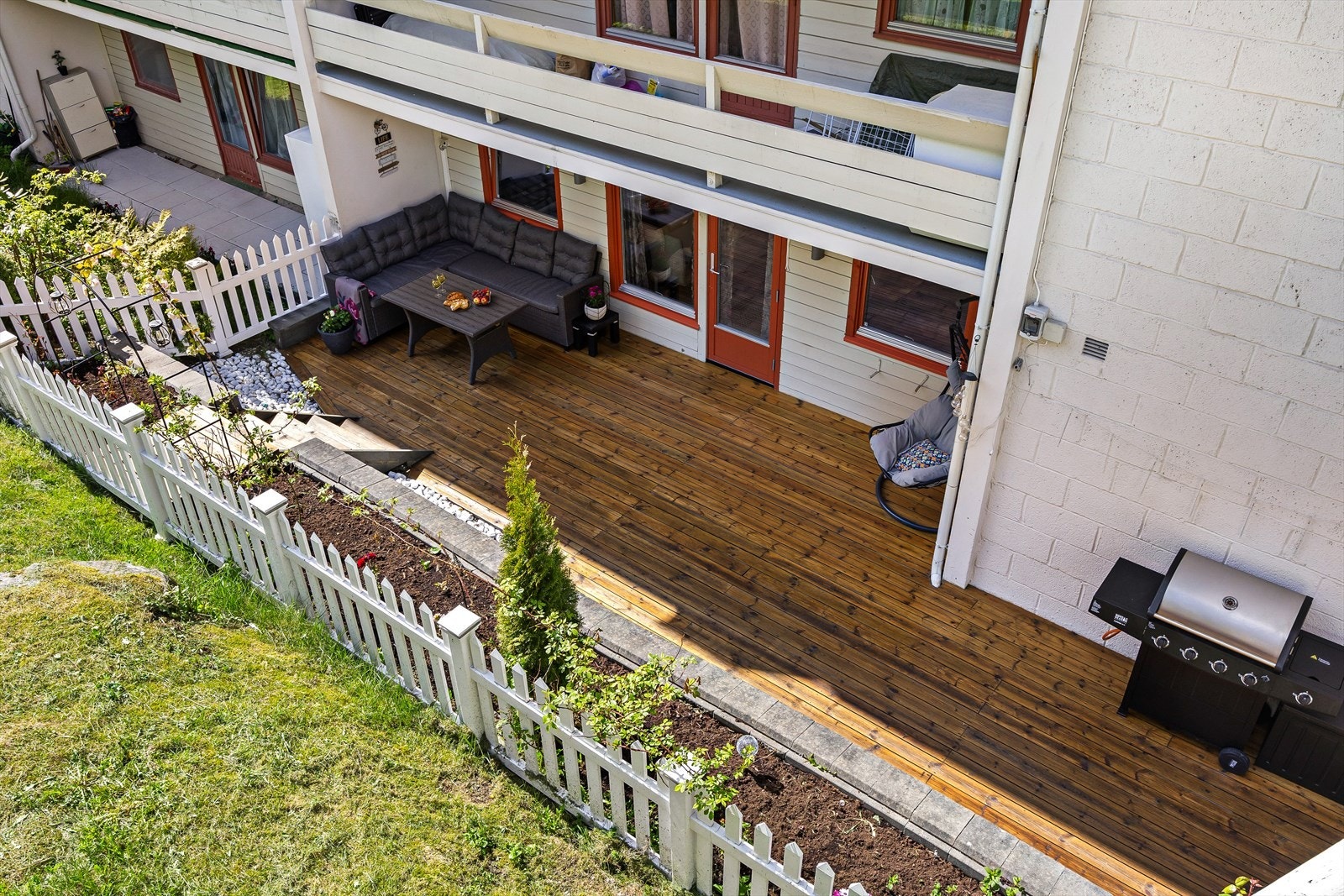 Terrassen er pent opparbeidet med bed og avgrenset av et stakittgjerde med innebygd belysning. Galleribilde