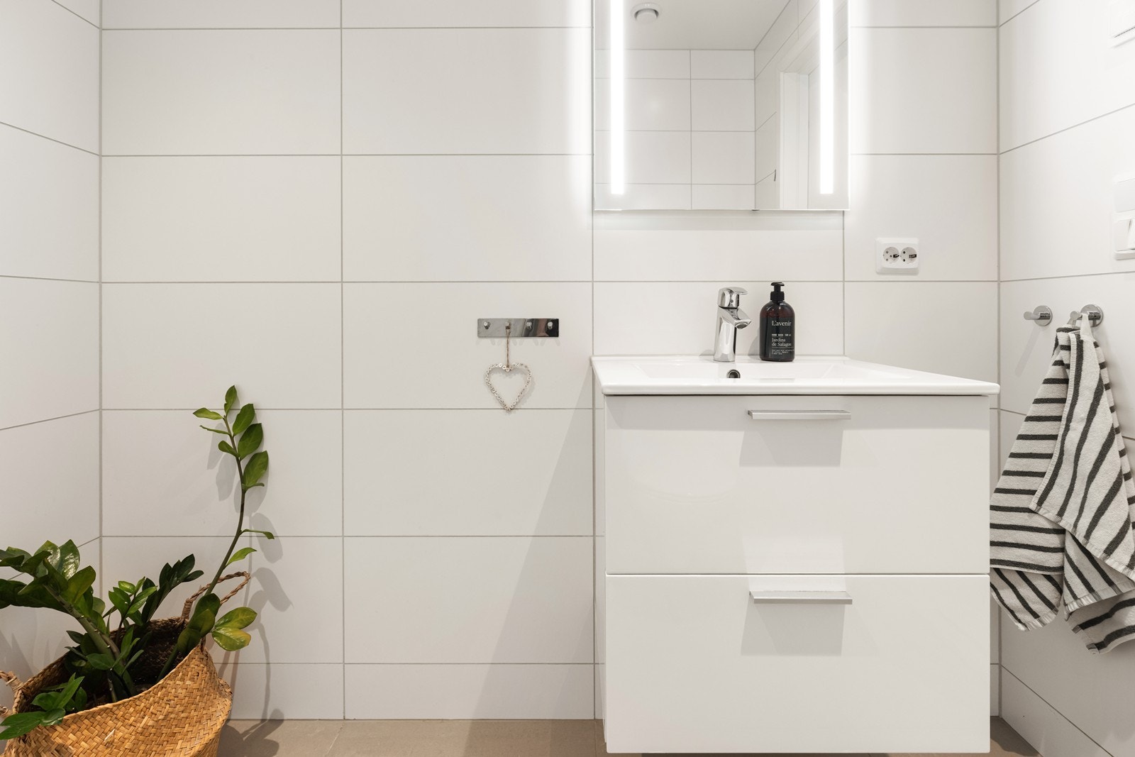 Badet i øvre etasje er helfliset og har gulvvarme, servantskap med glatte fronter og speil med integrert belysning. Galleribilde