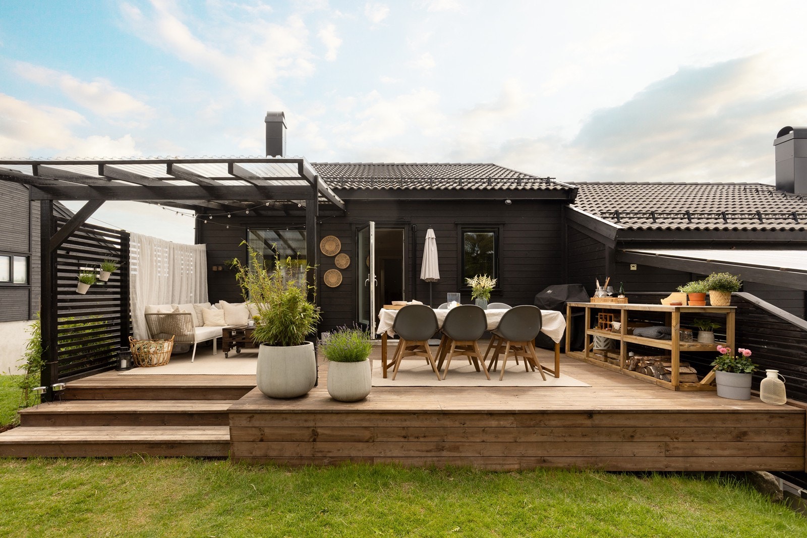 Uteplassen er pent opparbeidet med plen og en stor treterrasse. Galleribilde