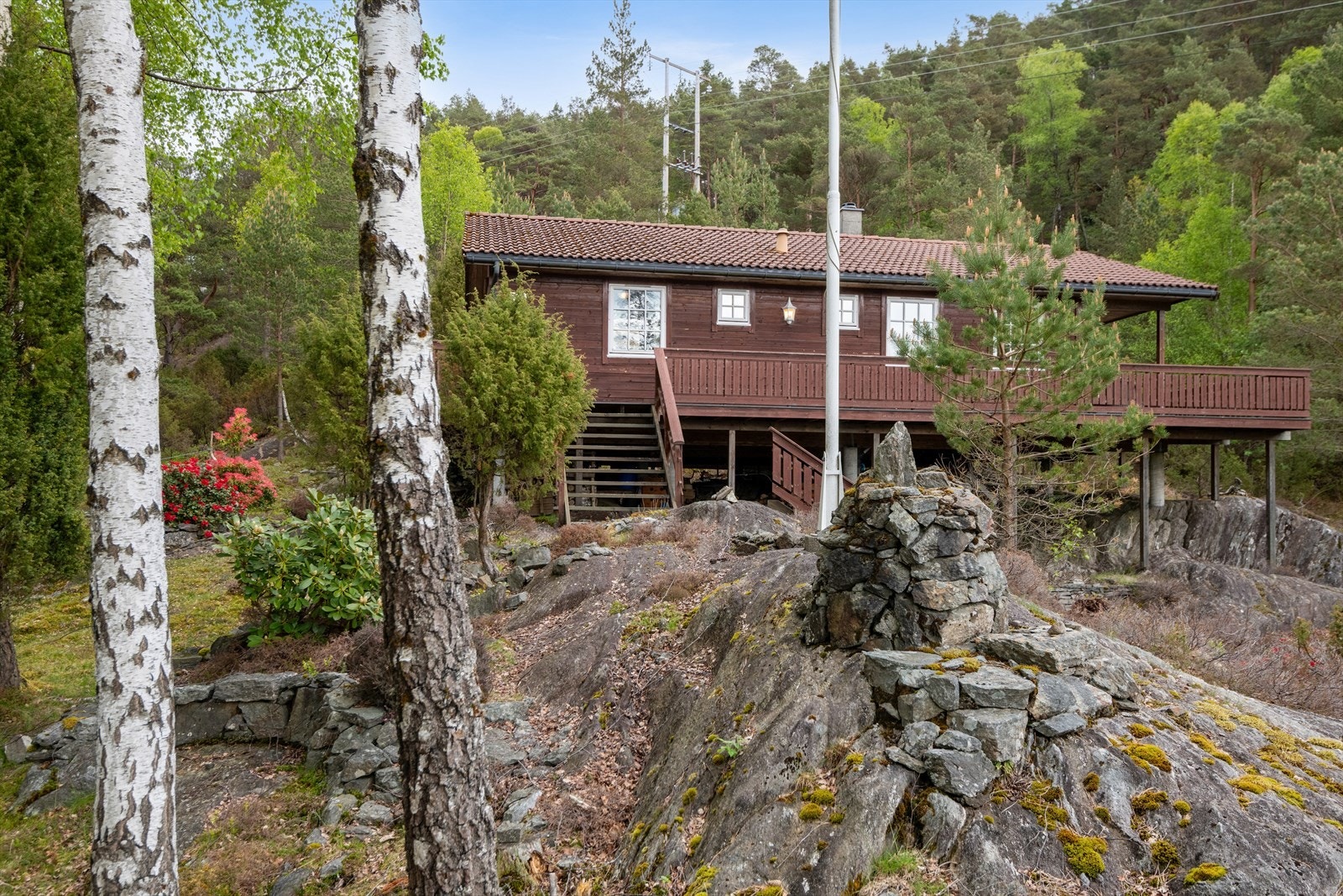 Tomten er kupert og består i hovedsak av naturtomt med berg, lyng og trær. Galleribilde