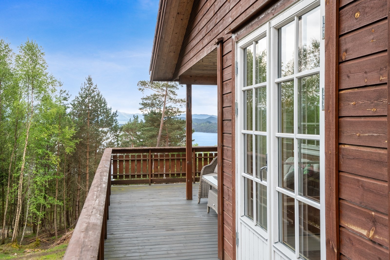 Fra terrassen er det utsikt over skogen og ned mot sjøen. Galleribilde