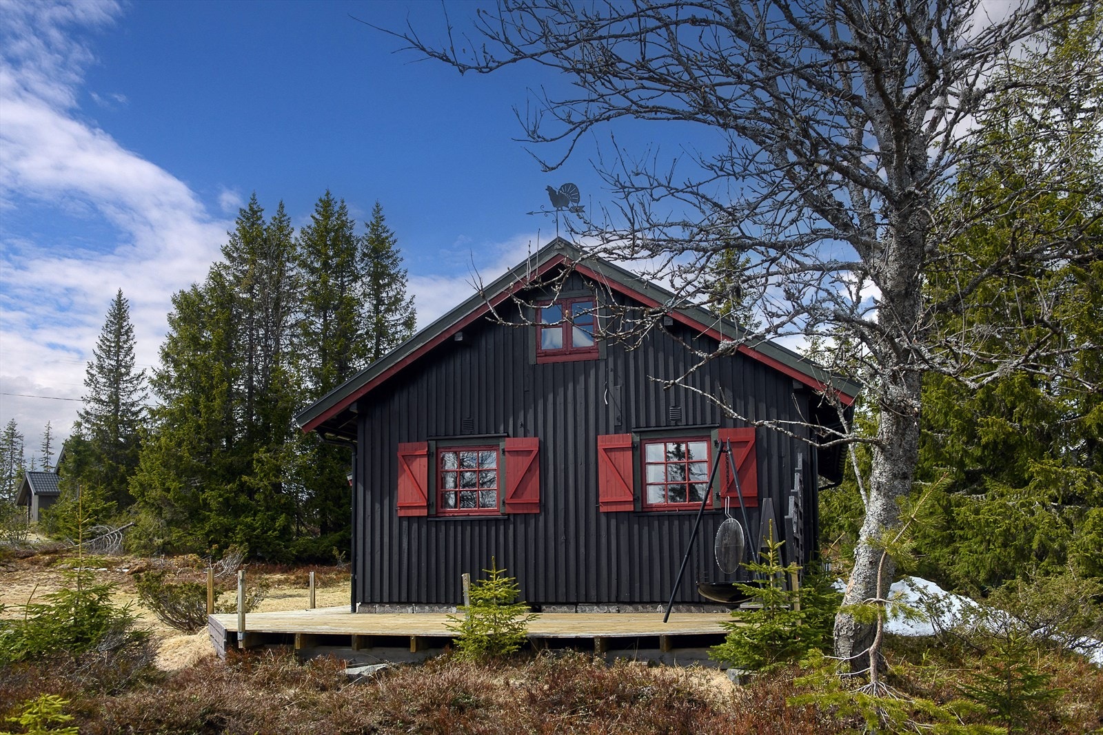 Hytta har en klassisk utforming med stående lektepanel og tak tekket med metallplater. Galleribilde