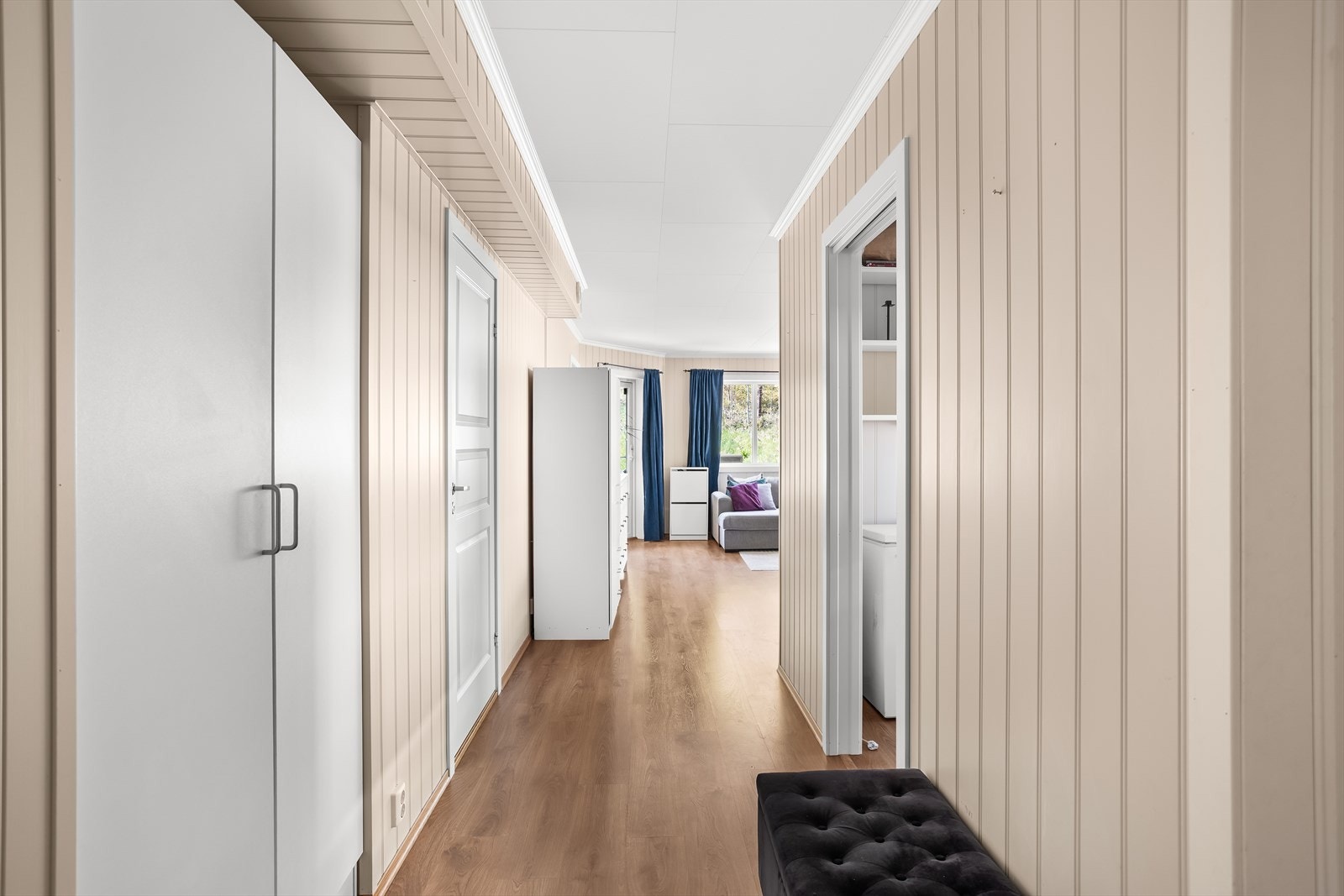 Fra gangen er det en åpen siktlinje gjennom stuen og ut mot hagen. Galleribilde