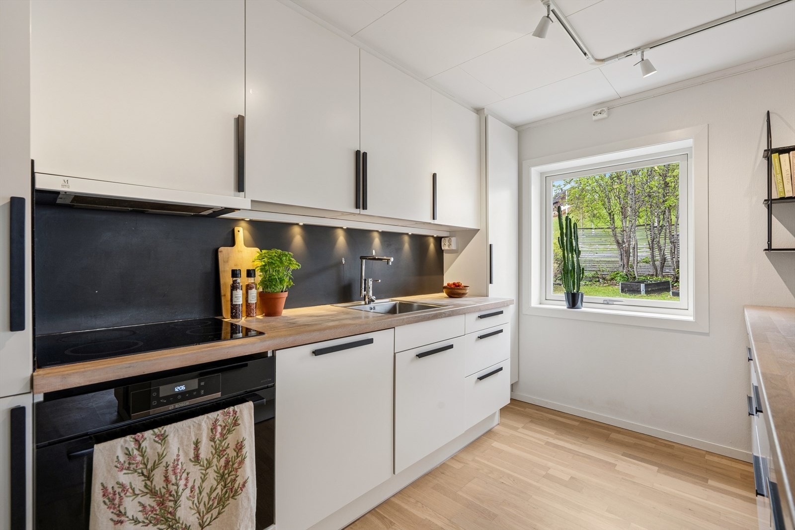 Leiligheten har en åpen stue- og kjøkkenløsning. Kjøkkenet er utstyrt med heltre benkeplater og integrerte hvitevarer. Galleribilde