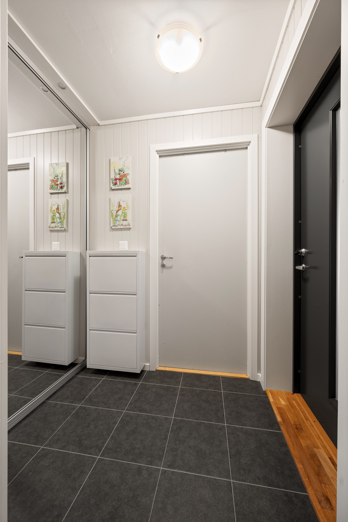 Flislagt entré med skyvedørsgarderobe med speildører Galleribilde