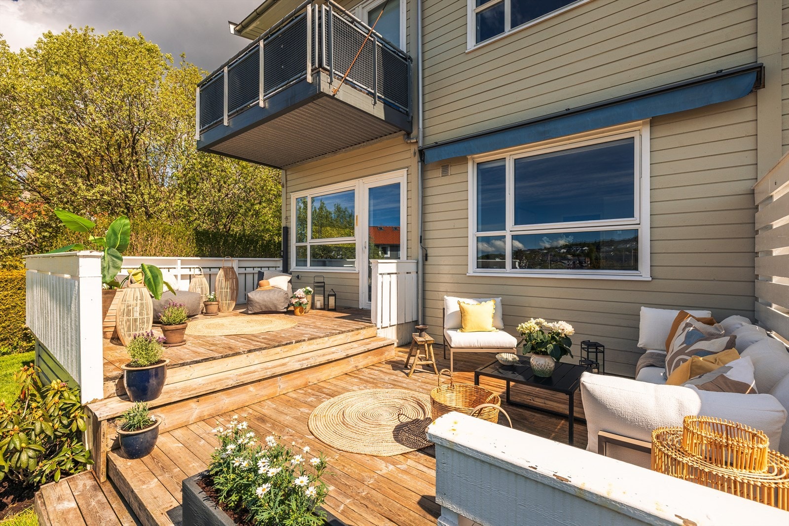 Solrik terrasse med frodig hage i front, perfekt for avslapning og underholdning. Galleribilde