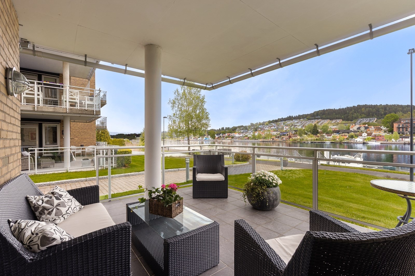 Terrassen ligger på bakkeplan er overbygget av balkongen i etasjen over, noe som gir ly for regn og direkte sol. Galleribilde