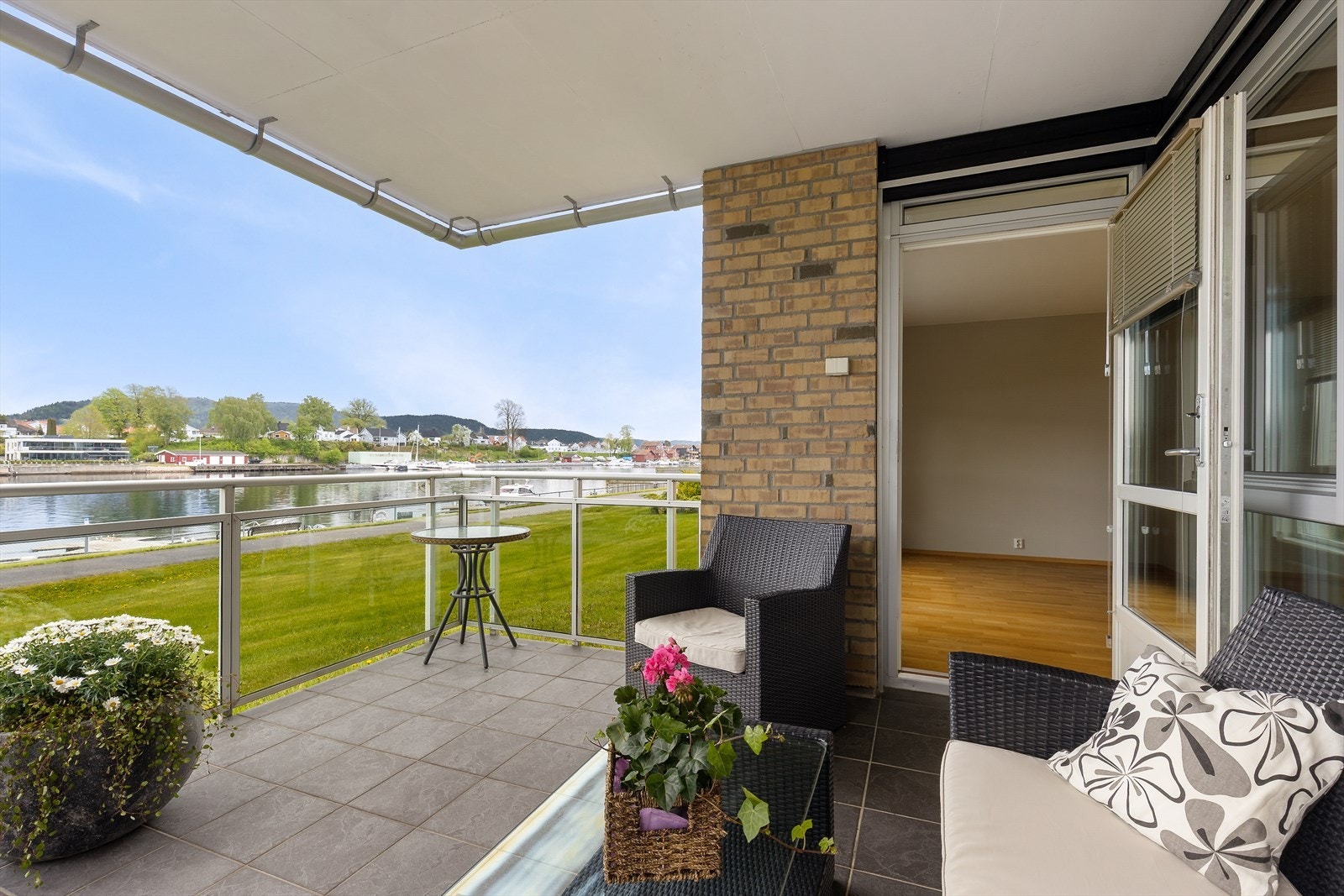 Gulvet er utført med flis på underliggende betong, og rekkverket er i glass og aluminium. Utsikten mot elva er vid og åpen. Galleribilde