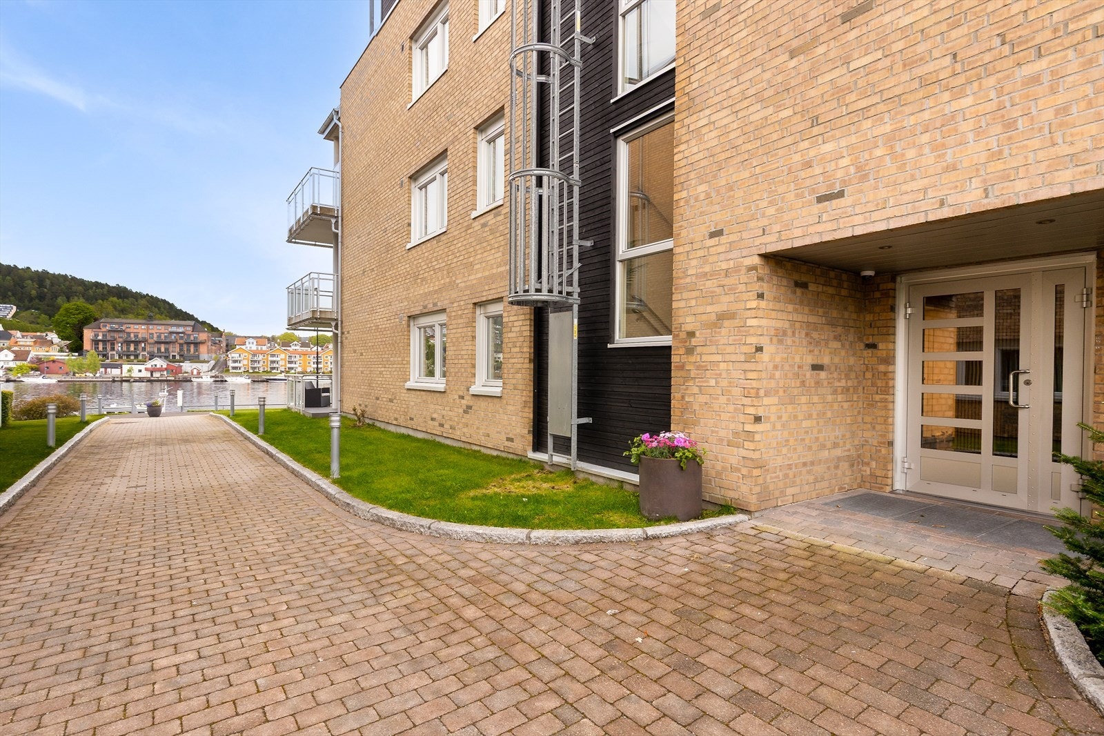 Felles, overbygget inngangsparti på bakkeplan. Bygningen fra 2009 er oppført i betong og er utvendig kledd med teglstein. Galleribilde