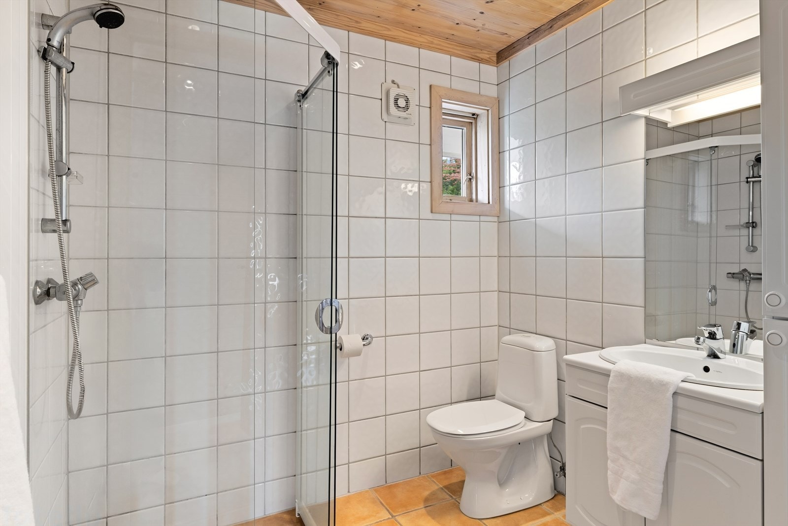 Badet i første etasje har flislagt gulv med elektriske varmekabler, dusjhjørne og servant. Galleribilde