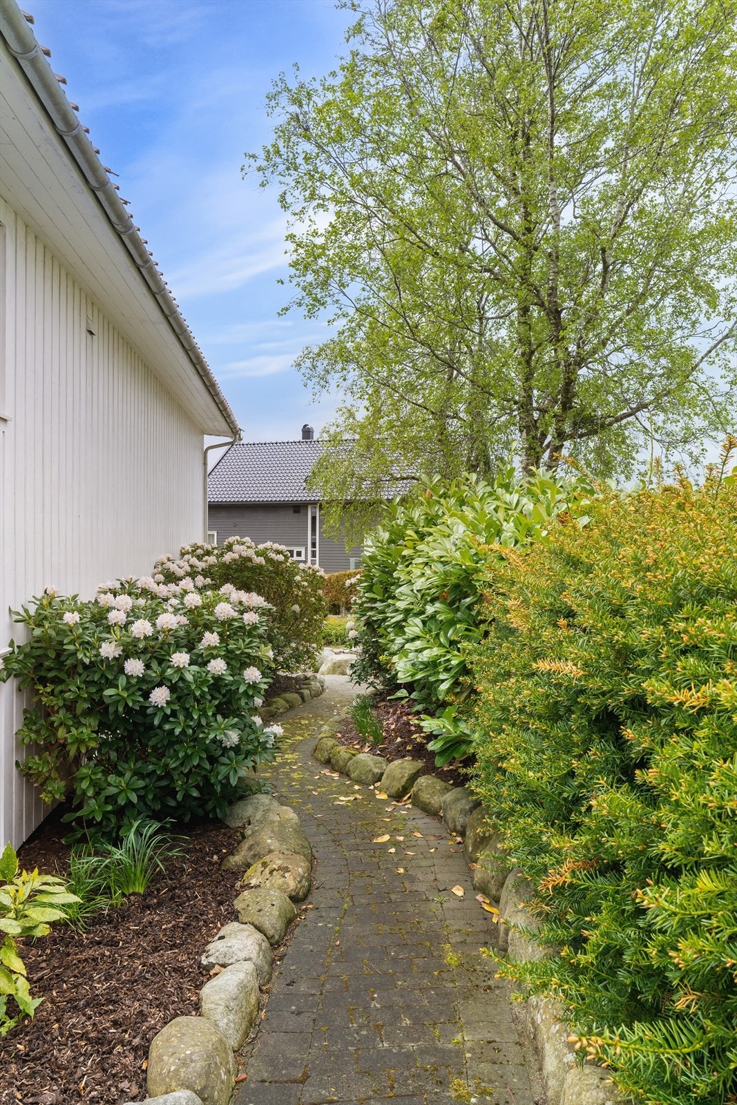 En sjarmerende sti med belegningsstein leder langs siden av huset. Galleribilde