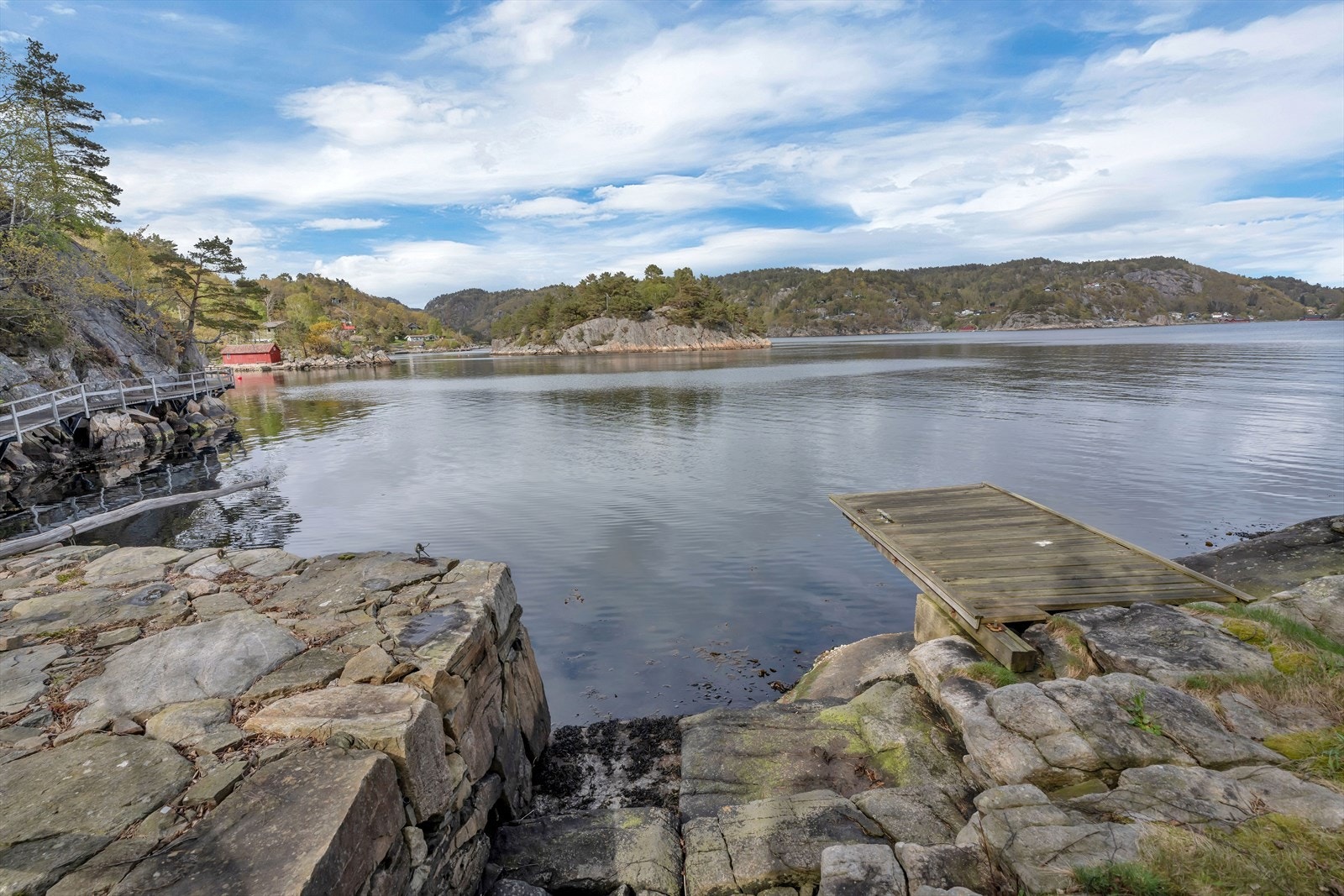 En steinvor gir en lun havn for en mindre båt. Galleribilde