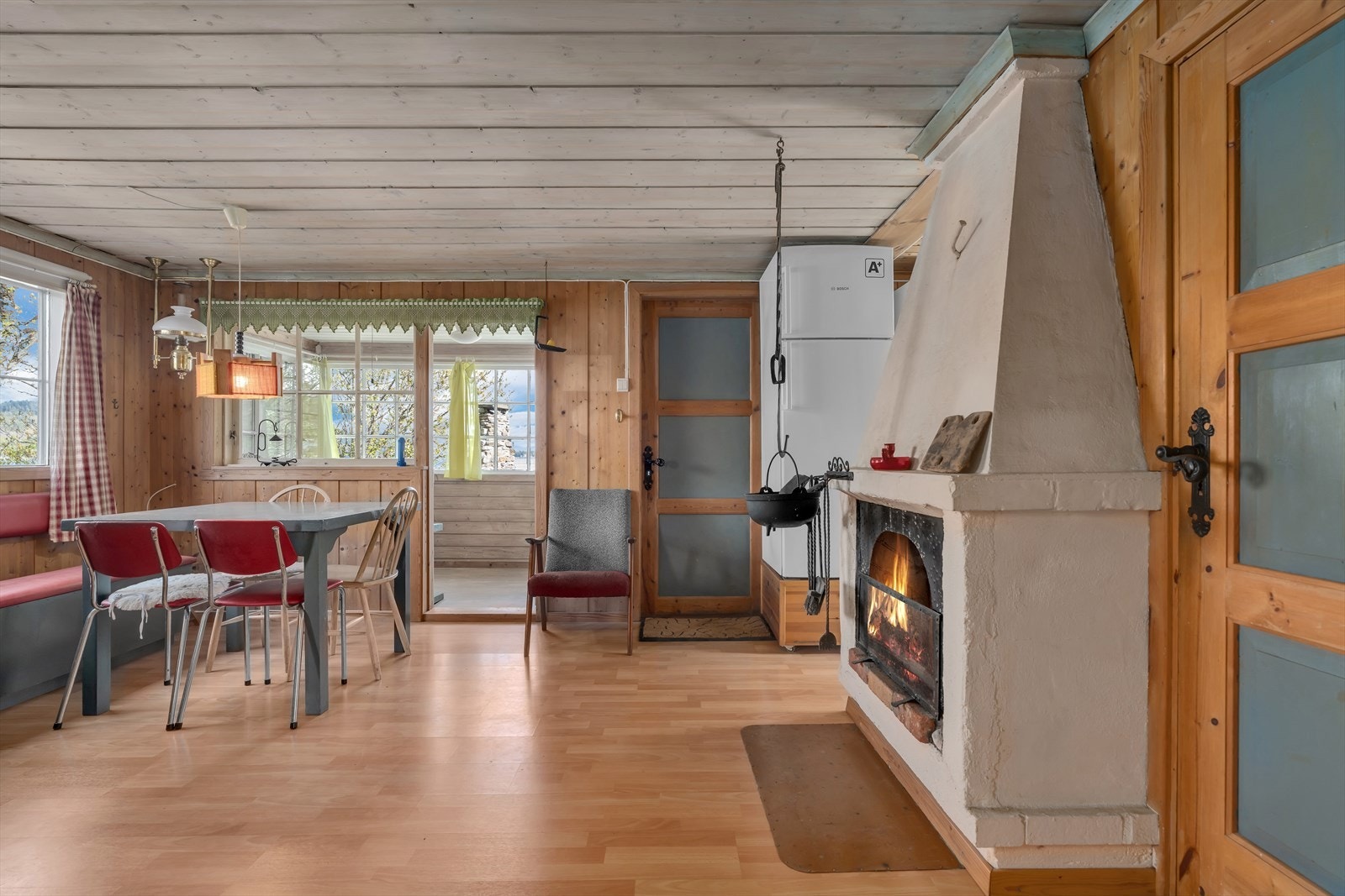 Stuen er et naturlig samlingspunkt med en åpen peis som gir både varme og stemning. Galleribilde