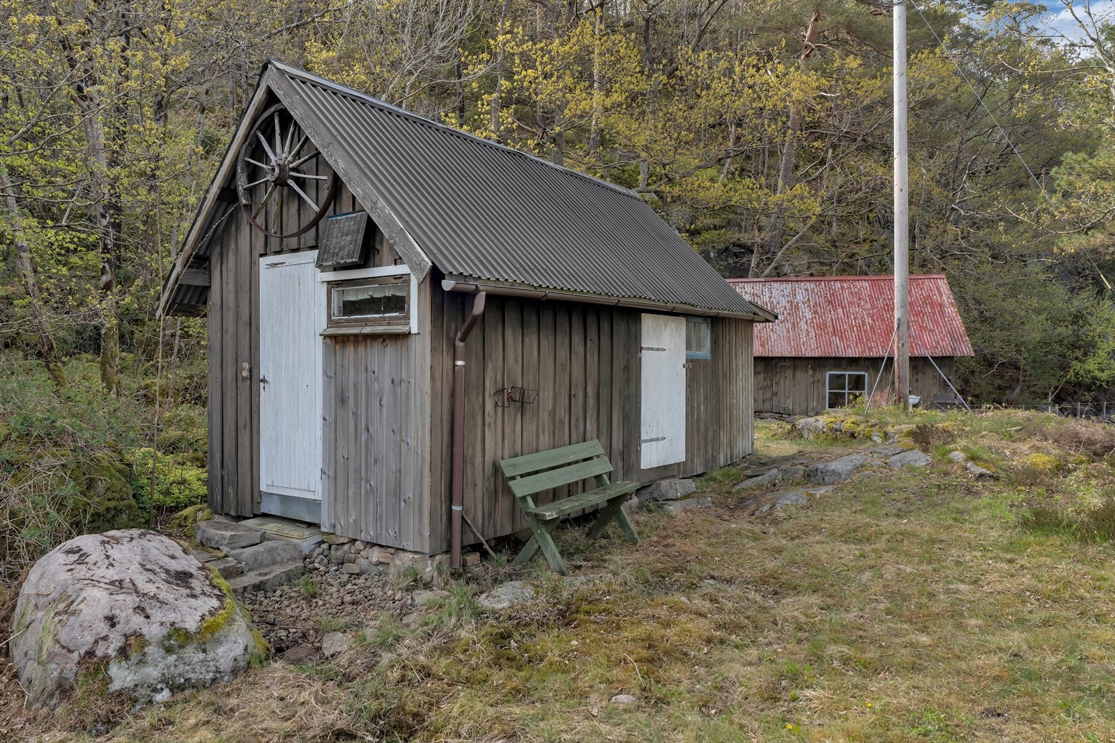 Uthusene har stående bordkledning og saltak med stålplater. Galleribilde