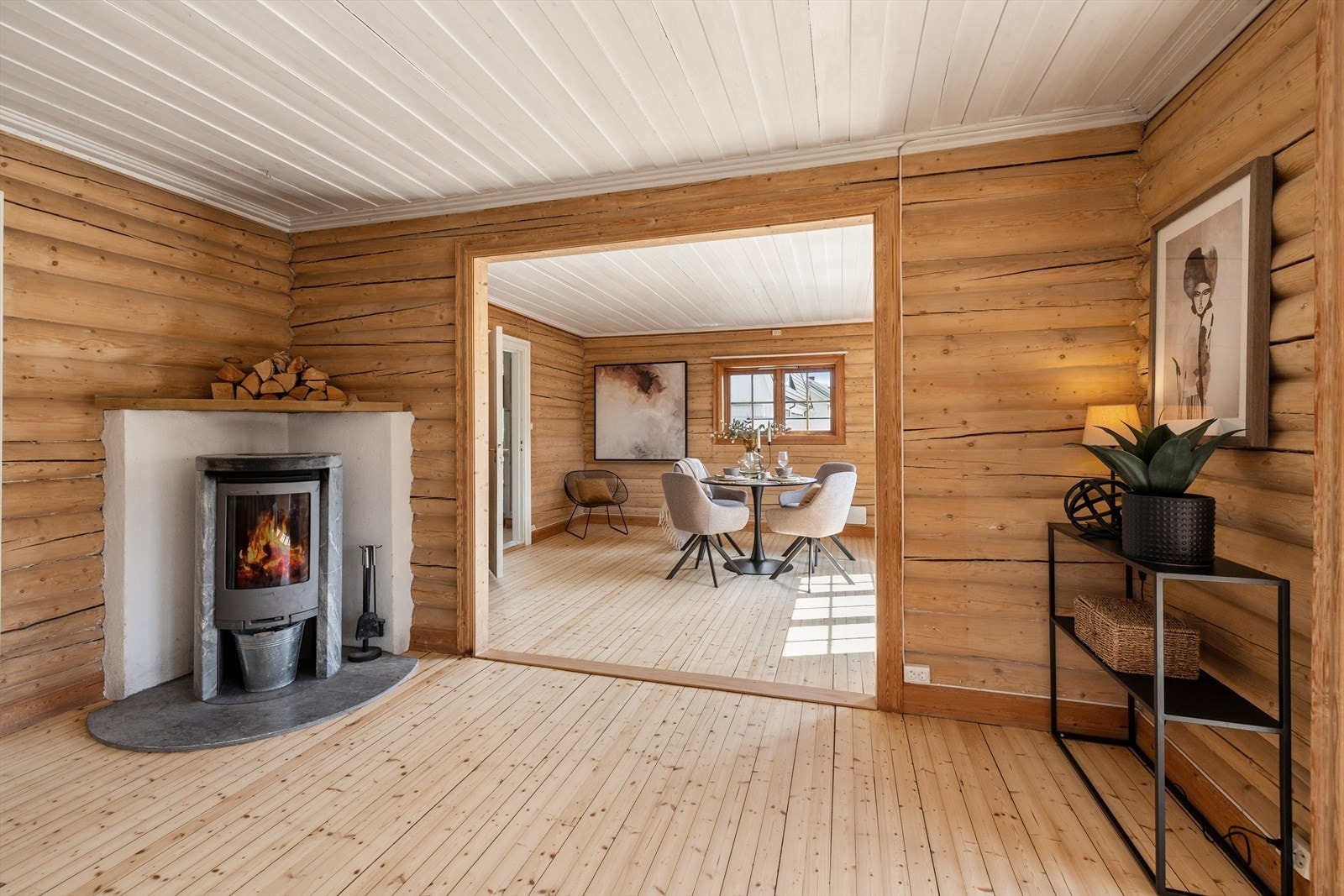 Peisovnen skaper både varme og hygge, og en bred åpning mot spisestuen bidrar til en naturlig og åpen sammenheng mellom rommene. Galleribilde