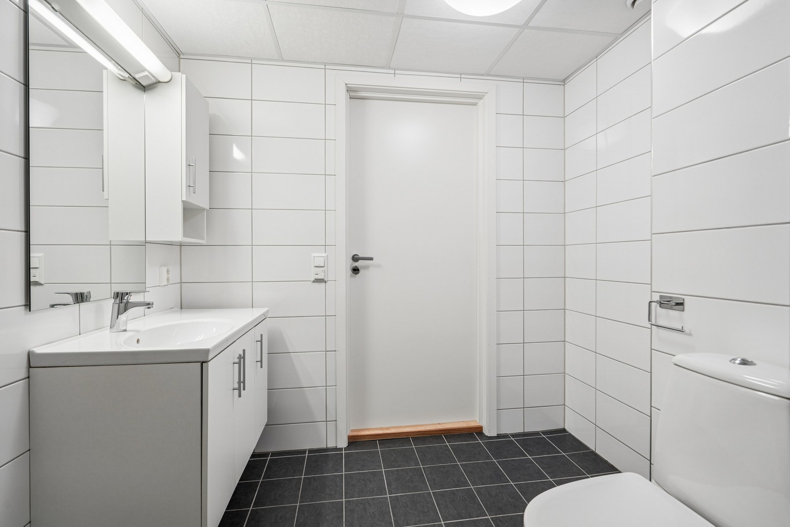 Flislagt bad fra 2014 med innredning med overliggende servant og toalett. Galleribilde