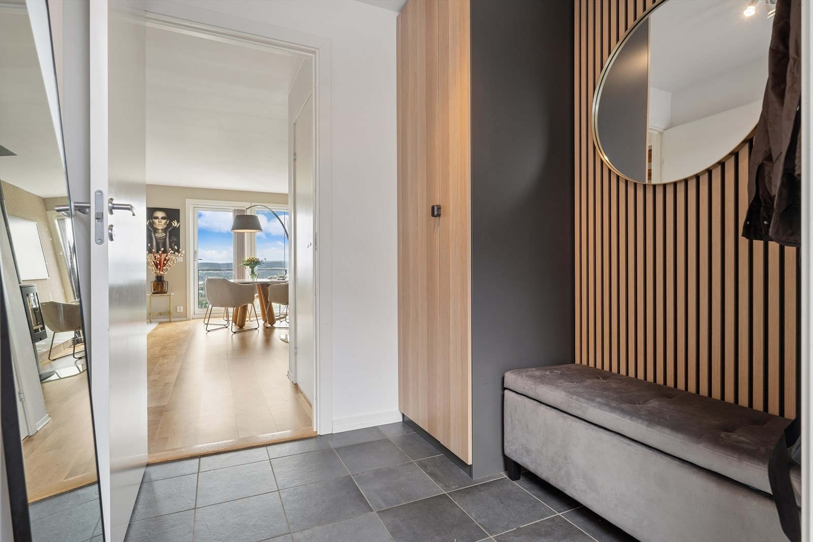 Velkommen inn til en lys og flislagt entré. Det er gode oppbevaringsmuligheter for yttertøy og til å sette ifra seg sko, noe som gjør det enkelt å holde orden i inngangspartiet. Galleribilde