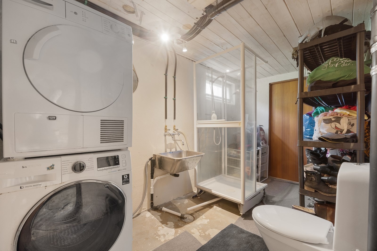 Praktisk vaskerom i kjelleren med opplegg for vaskemaskin, skyllekum, toalett og dusjkabinett. Galleribilde