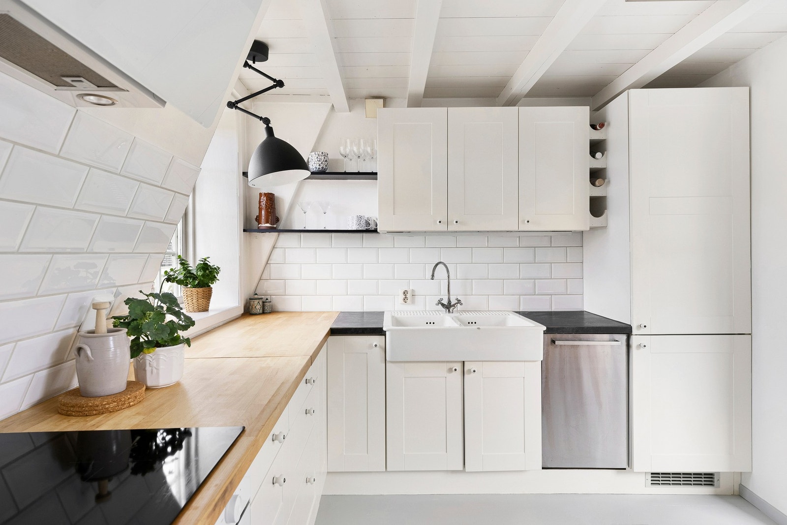 Kombinasjonen av lyse flater, klassiske detaljer og benkeplater i tre og mørkere materiale gir kjøkkenet et varmt og innbydende uttrykk. Galleribilde
