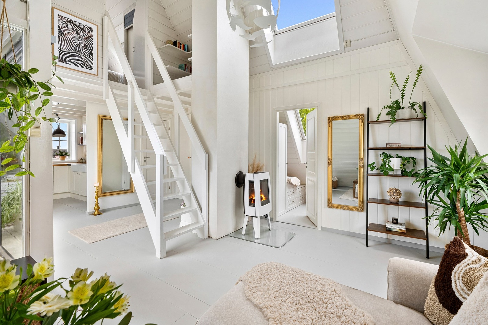 Leiligheten har et gjennomført uttrykk med lyse overflater, skråtak og spennende arkitektur som gir en unik romfølelse. Galleribilde