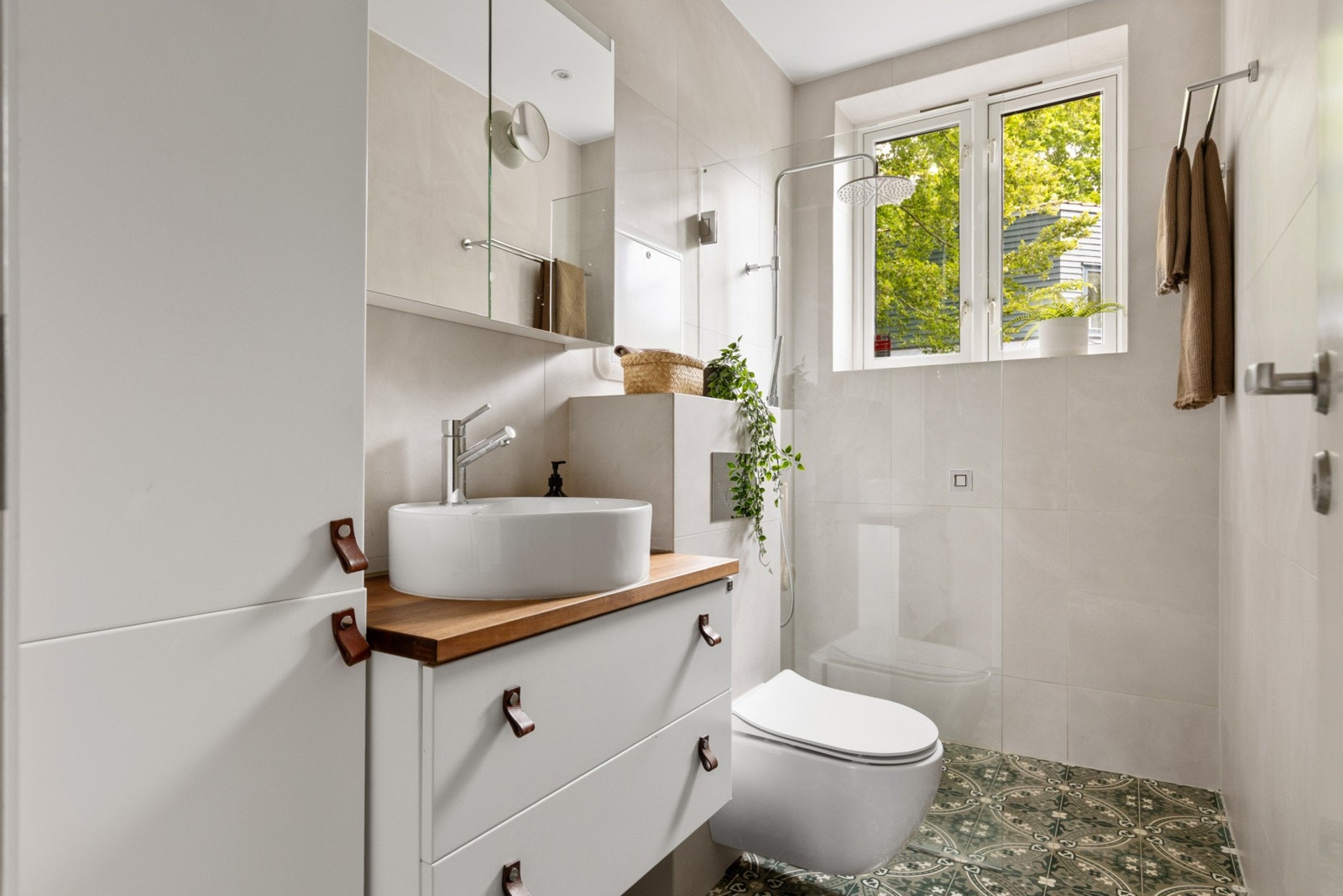 Flislagt gulv med varmekabler, flislagte vegger og malt himling med downlights. Galleribilde