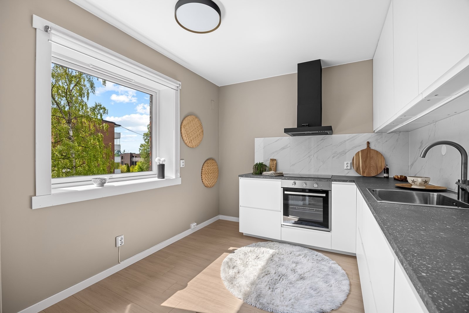 Moderne kjøkken fra 2026 med integrert stekeovn, koketopp og oppvaskmaskin, samt komfyrvakt og ventilator. Galleribilde
