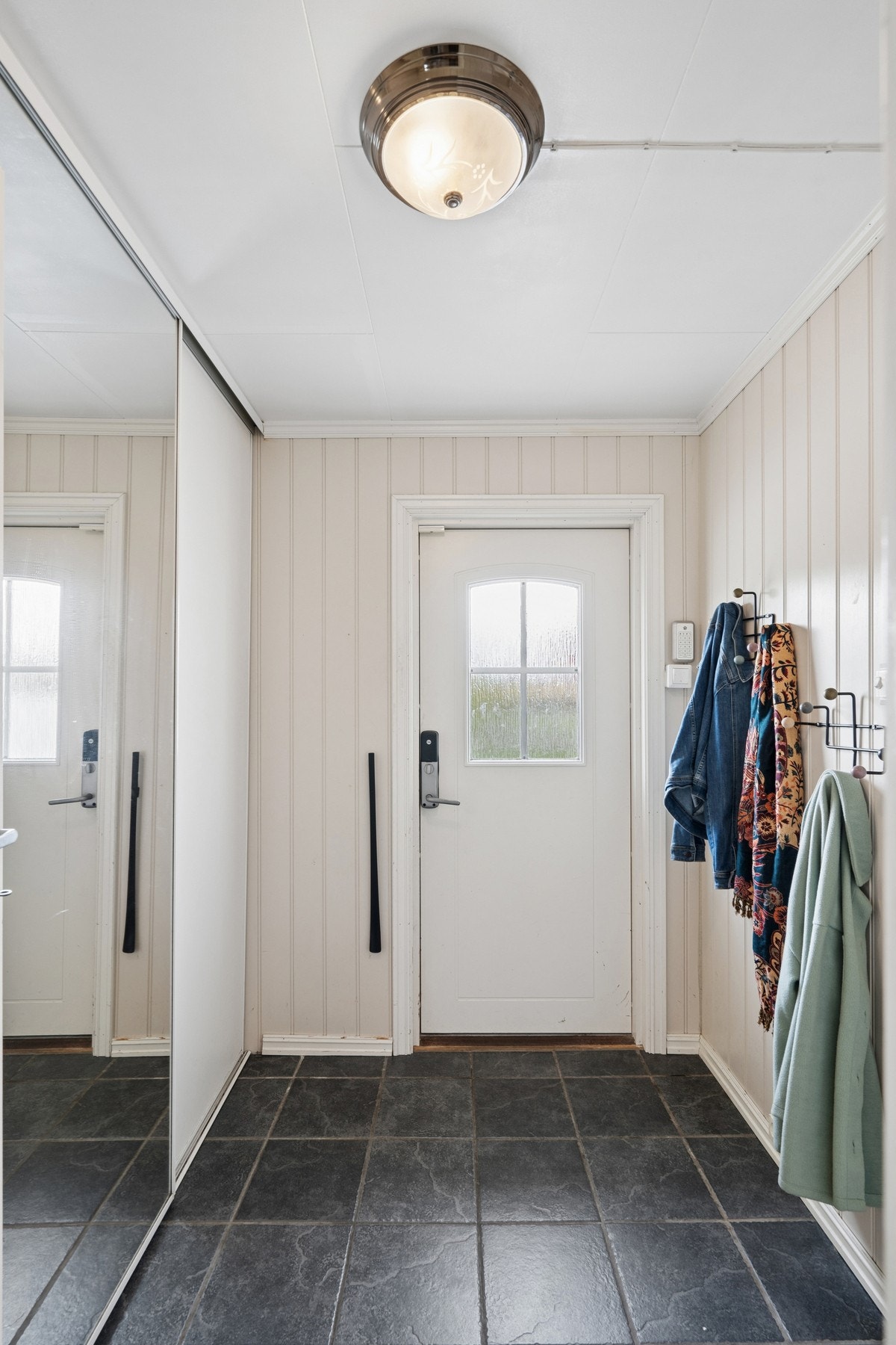 Velkommen inn! Boligen entres på hovedplan, hvor en romslig entré/gang venter. Rommet gir plass for oppbevaring i skyvedørsgarderobe, samt ulike opphengsløsninger. Galleribilde