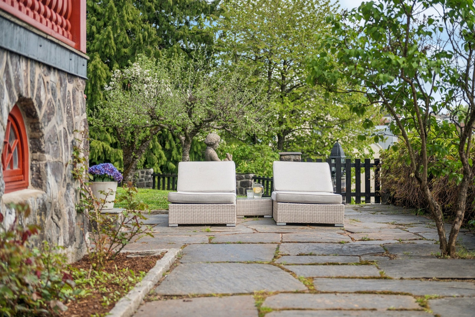 Skiferlagt terrasse i hagen. Her er det god plass til flere oppholdssoner. Galleribilde