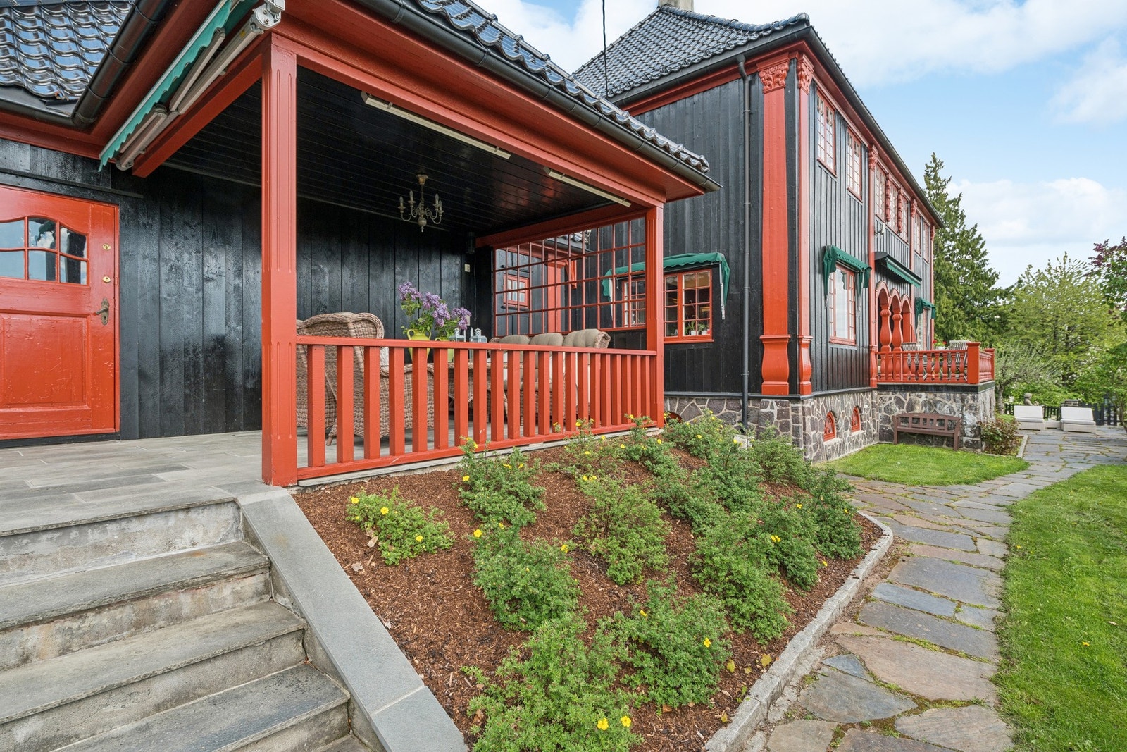 Grillterrassen sett fra hagen. Pent opparbeidet med fin beplantning hele veien. Galleribilde