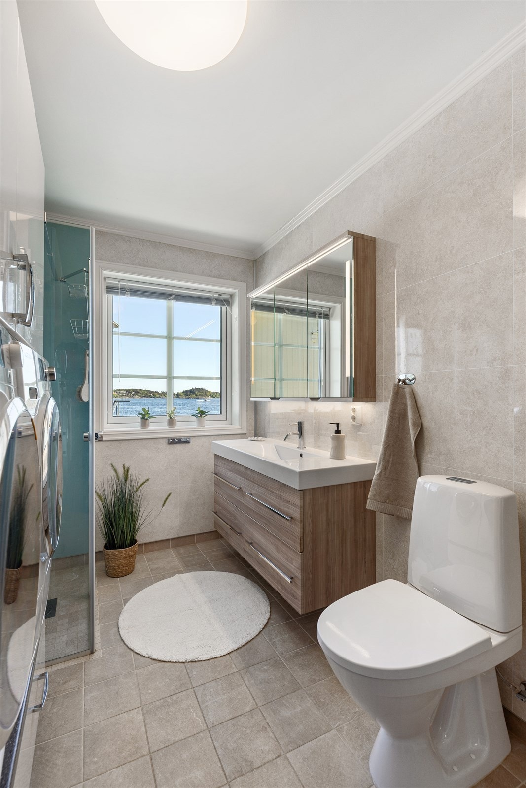 Rommet inneholder wc, servant og dusjhjørne med glassvegger. Galleribilde