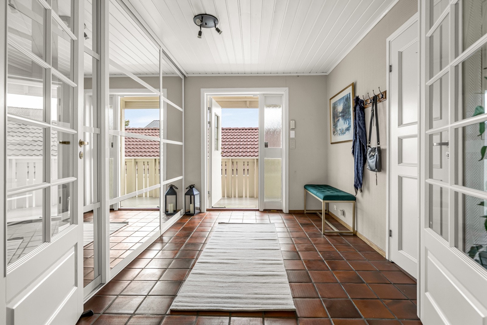 Flislagt entré med skyvedøregarderobe med speildører og plass til oppheng av jakker. Galleribilde