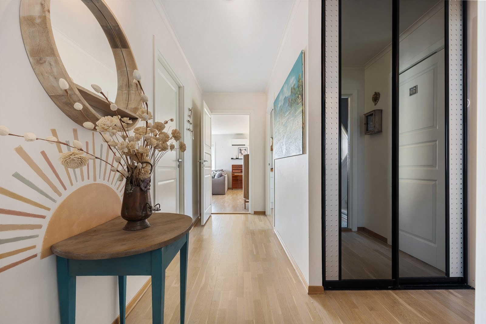 Via et lyst inngangsparti kommer du inn i en åpen gang med gode oppbevaringsmuligheter, blant annet skyvedørsgarderobe og plass til oppheng av yttertøy. Galleribilde