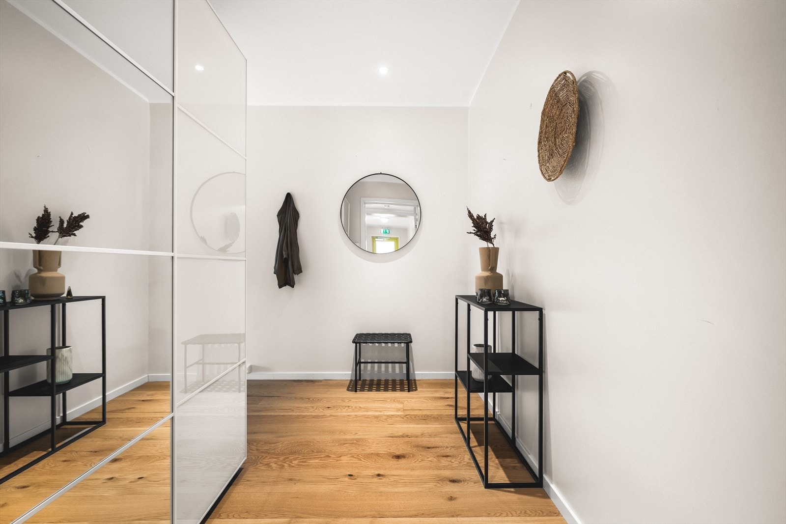 Velkommen inn i en lys og innbydende gang, innredet med en romslig skyvedørsgarderobe. Galleribilde