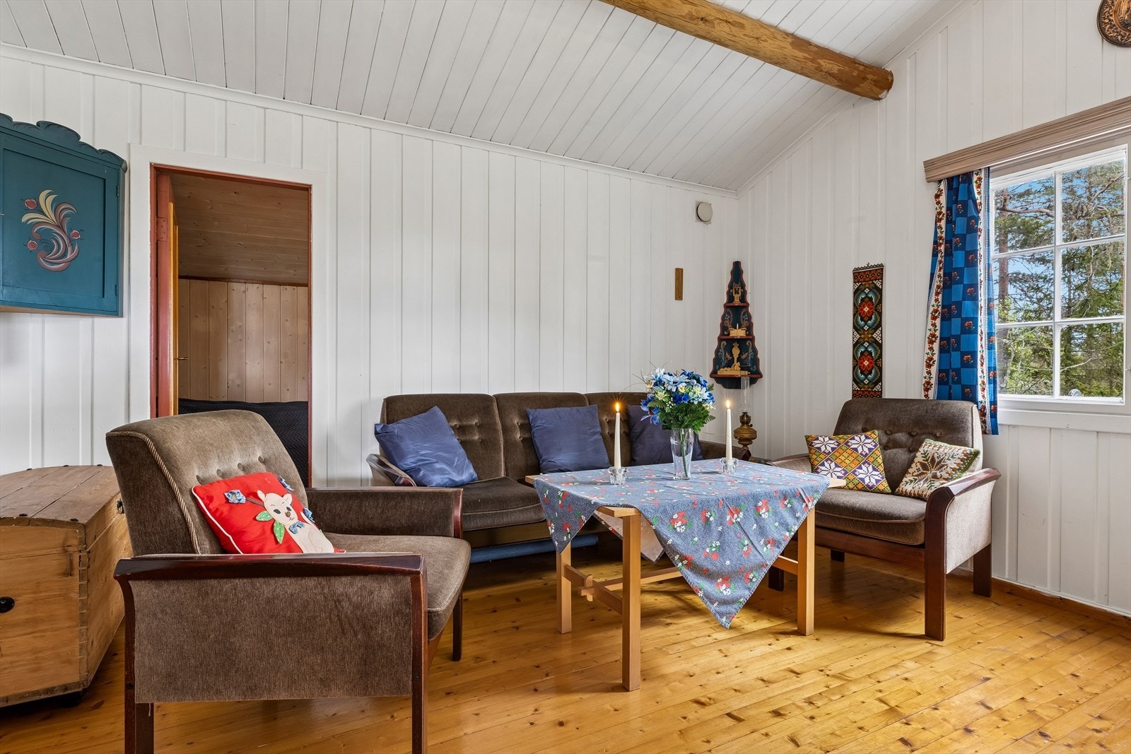 Overflatene består av lakkert tregulv og malt trepanel på vegger. Galleribilde