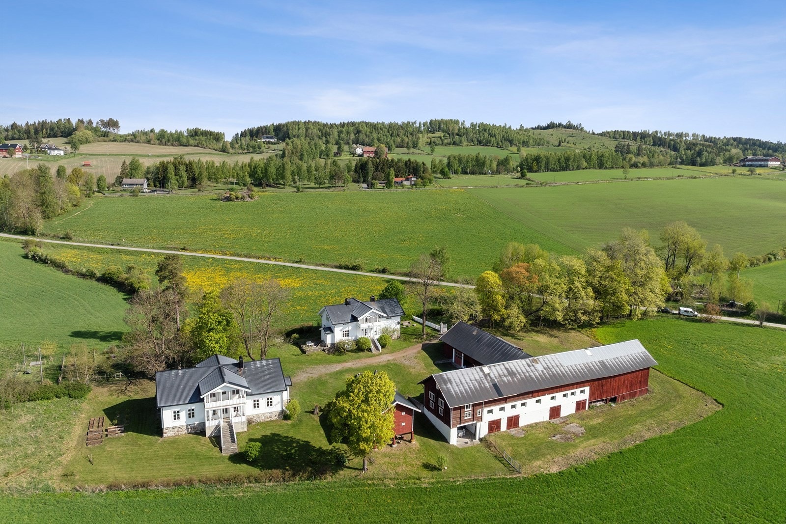 Et idyllisk småbruk med en sentral plassering av bygningsmassen på tomten. Galleribilde