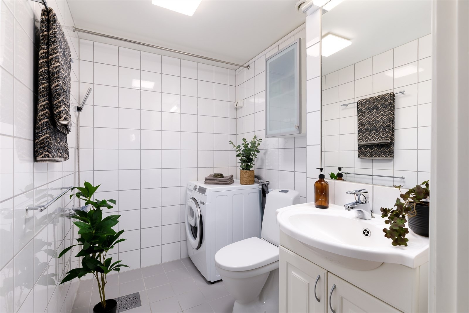Bad fra byggeår, brukes i dag som vaskerom. Badet er flislagt og har elektriske varmekabler i gulvet. Videre er det gulvstående toalett, 60 cm servant med underskap og opplegg for dusj/badekar. Opplegg for vaskemaskin. Galleribilde