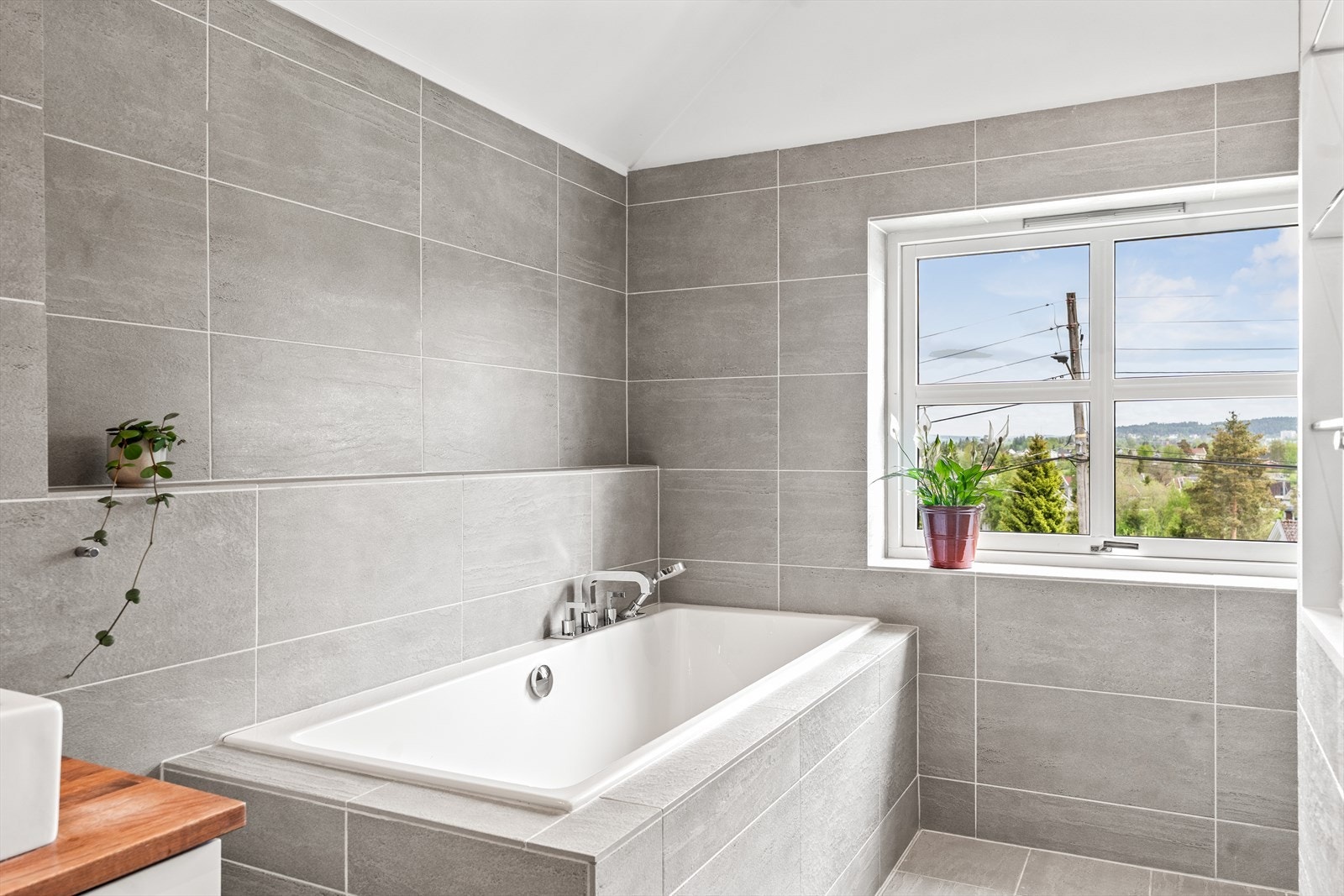Badet har flere gode kvaliteter som downlights, store grå gulvfliser og veggfliser samt gulvvarme. Galleribilde