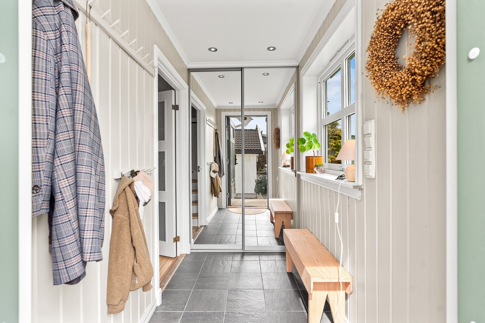 Boligen har en svært innbydende entré. Det er fliser på gulv, gulvvarme, downlights og skyvedørsgarderobe med speilfronter. Galleribilde