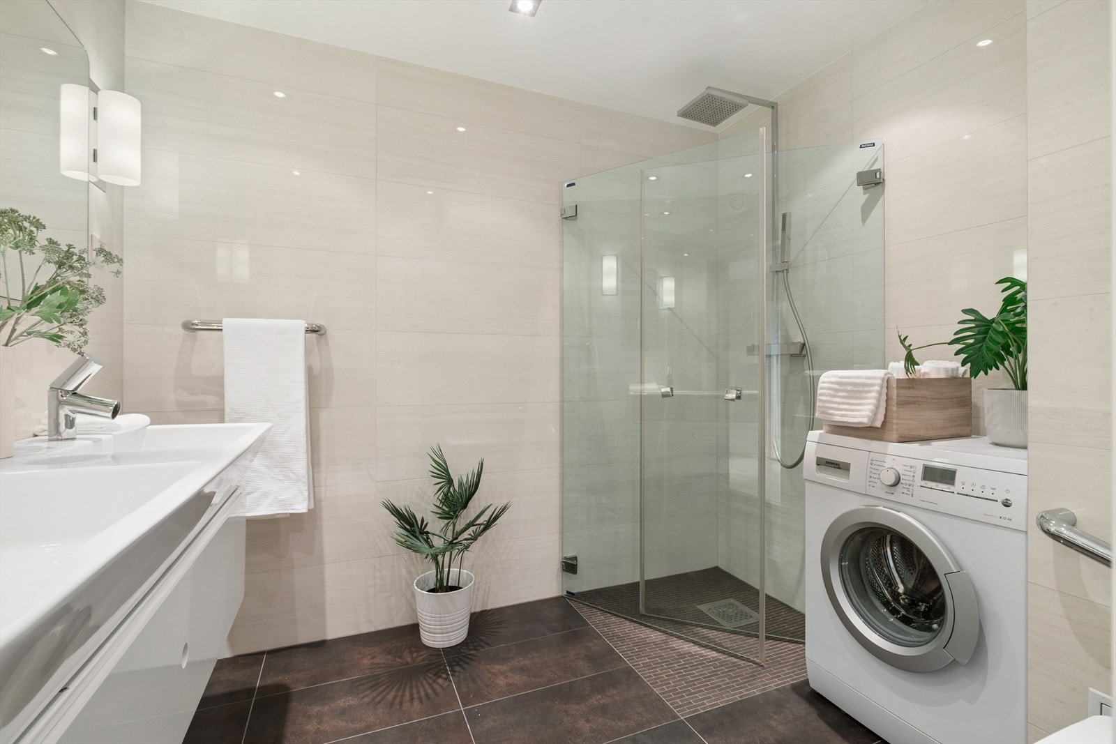 Badet har dusj med innfellbare vegger i herdet glass og praktisk opplegg for vaskemaskin. Galleribilde