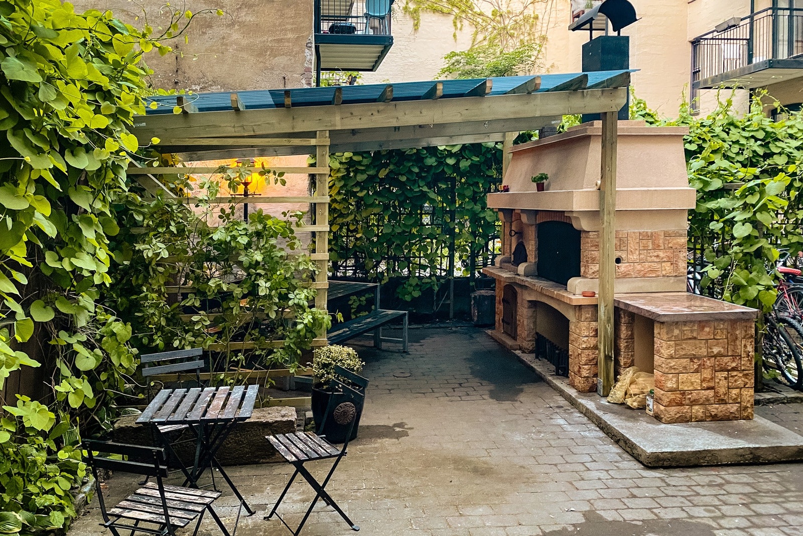 Hyggelige fellesarealer bestående av en pent renovert pergola med sittegrupper, fellesgrill og pizzaovn. Galleribilde