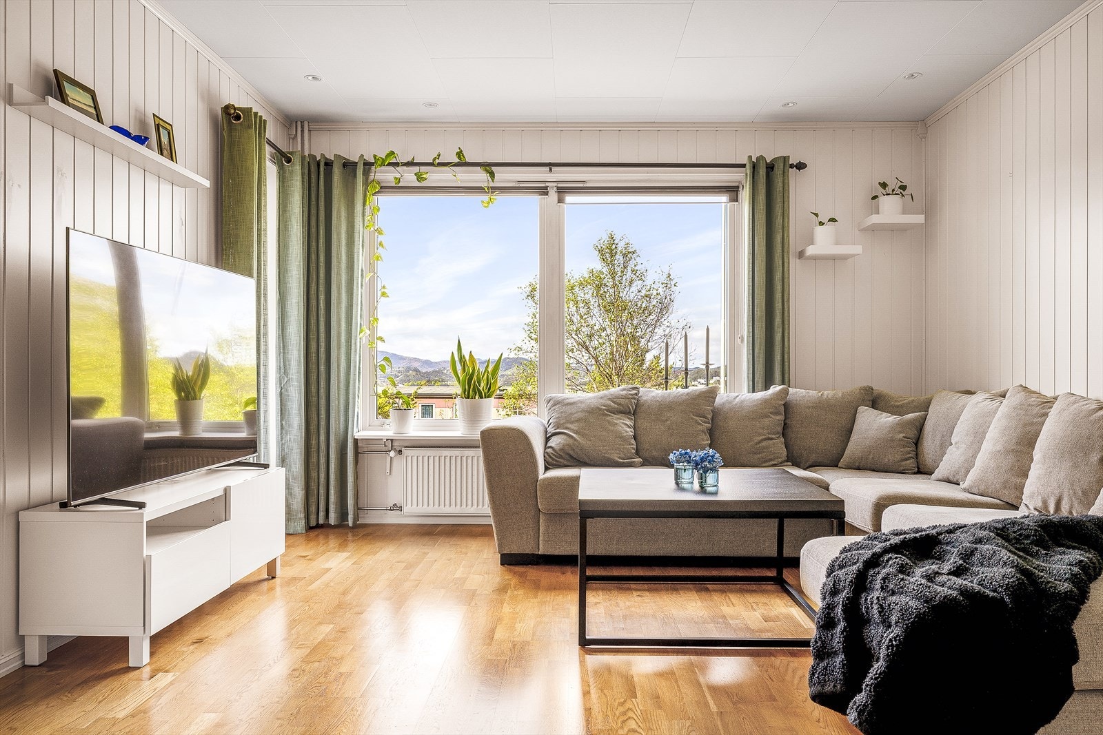 Stuen har store vinduer som slipper inn rikelig med naturlig lys og byr på en flott utsikt Galleribilde