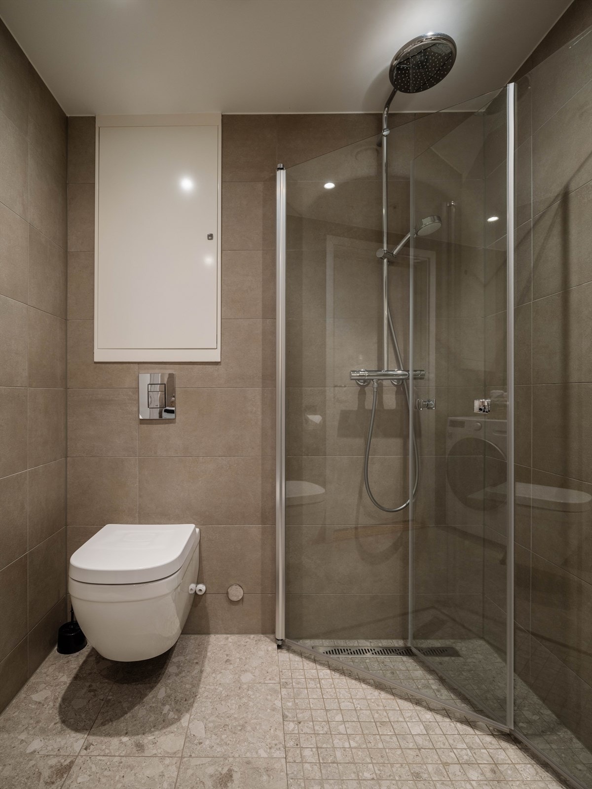Videre har badet en romslig dusjplass bak innfellbare dører i herdet glass. Galleribilde