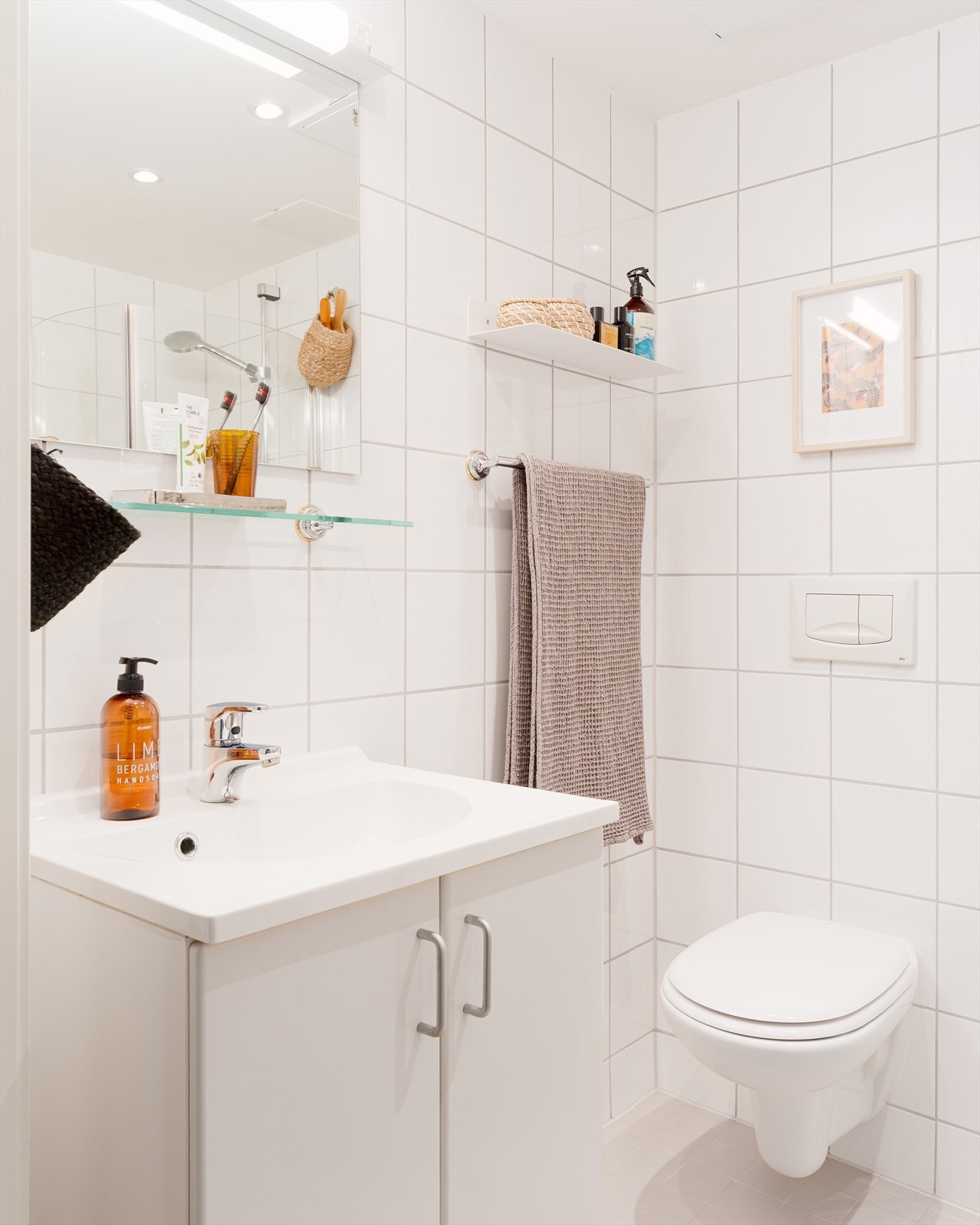 Baderomsinnredning med heldekkende servant, veggmontert toalett og downlights i himling. Galleribilde