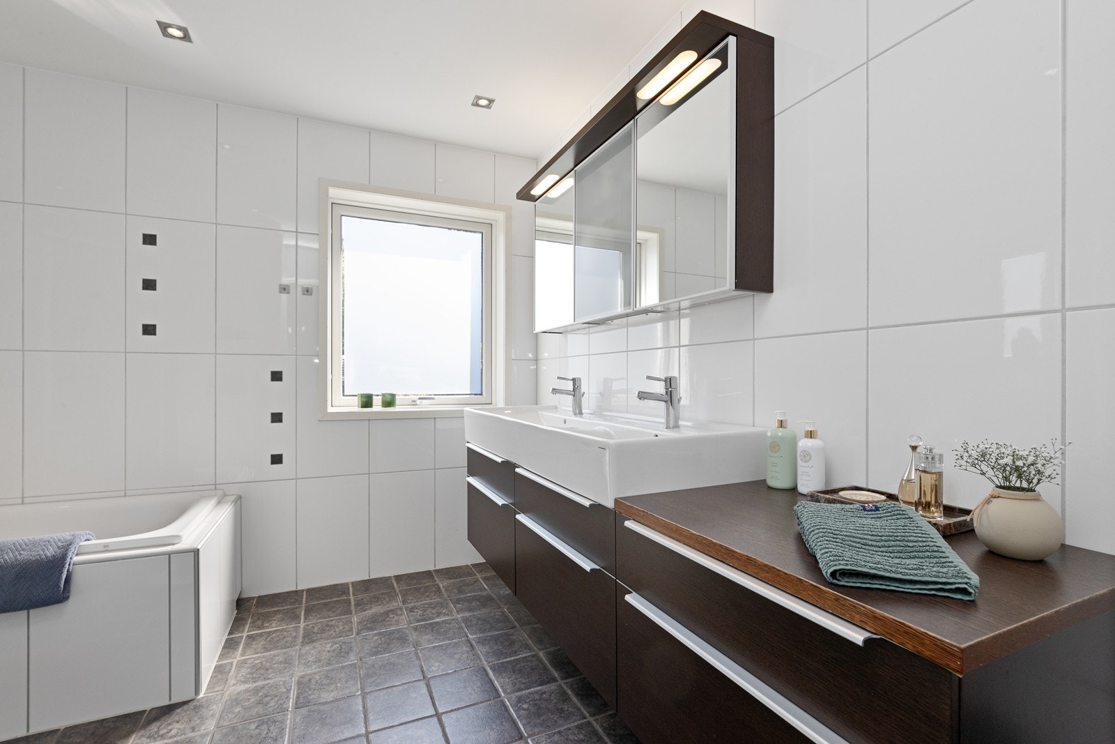 Badet har flislagt gulv med gulvvarme og downlights i taket. Galleribilde