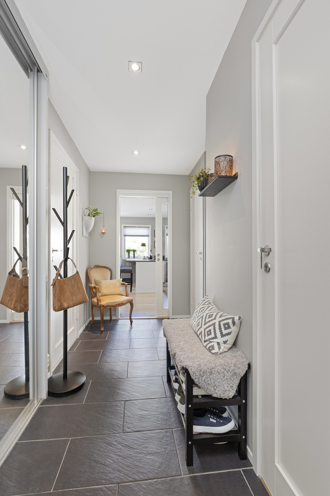 Entré med flislagt gulv, gulvvarme og en praktisk skyvedørsgarderobe med speilfronter. Galleribilde